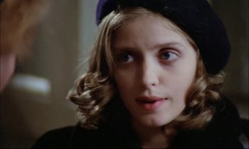 Movie still from “The Tin Drum” (1979), directed by Volker Schlöndorff – A person wearing a hat and looking at the camera; Close Up shot, High angle