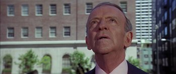 Movie still from “The Towering Inferno” (1974), directed by John Guillermin – An older man wearing a suit and tie looking up; Close Up shot, Low angle