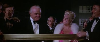 Movie still from “The Towering Inferno” (1974), directed by John Guillermin – A man and a woman are laughing at a party; Close Up shot, Over the shoulder angle