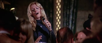Movie still from “The Towering Inferno” (1974), directed by John Guillermin – A woman singing into a microphone in front of a crowd; Medium shot, Low angle