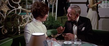 Movie still from “The Towering Inferno” (1974), directed by John Guillermin – A man and a woman sitting at a dinner table; Medium shot, Over the shoulder angle