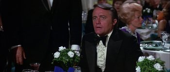 Movie still from “The Towering Inferno” (1974), directed by John Guillermin – A man in a tuxedo sitting at a dinner table; Close Up shot, Over the shoulder angle