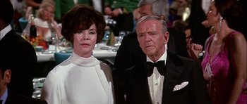 Movie still from “The Towering Inferno” (1974), directed by John Guillermin – An older man and a younger woman standing next to each other; Close Up shot, Low angle