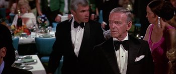 Movie still from “The Towering Inferno” (1974), directed by John Guillermin – Two men in tuxedos are standing in front of a table; Medium shot, Low angle