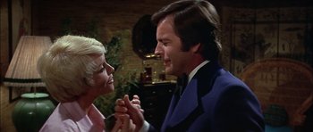 Movie still from “The Towering Inferno” (1974), directed by John Guillermin – A man and a woman holding hands and smiling at each other; Close Up shot, Low angle