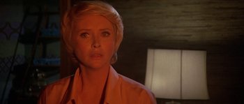 Movie still from “The Towering Inferno” (1974), directed by John Guillermin – A woman with blonde hair is looking at the camera; Close Up shot, Over the shoulder angle