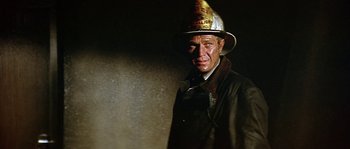 Movie still from “The Towering Inferno” (1974), directed by John Guillermin – A man wearing a fireman's hat in the dark; Close Up shot, Low angle