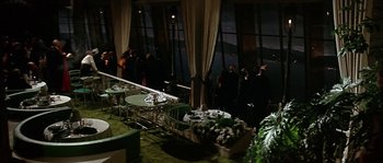 Movie still from “The Towering Inferno” (1974), directed by John Guillermin – A group of people standing in a room; Extreme Wide shot, High angle