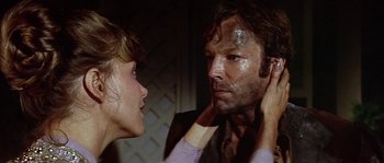 Movie still from “The Towering Inferno” (1974), directed by John Guillermin – A man and a woman looking at each other in front of a mirror; Close Up shot, Over the shoulder angle