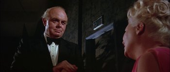 Movie still from “The Towering Inferno” (1974), directed by John Guillermin – An older man in a tuxedo standing in front of an exit sign; Close Up shot, Low angle