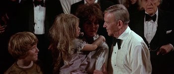 Movie still from “The Towering Inferno” (1974), directed by John Guillermin – An older man and a younger woman and a little girl; Close Up shot, High angle