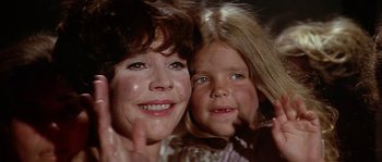 Movie still from “The Towering Inferno” (1974), directed by John Guillermin – A woman and a girl smiling for the camera; Close Up shot, Low angle