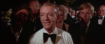 Movie still from “The Towering Inferno” (1974), directed by John Guillermin – An older man wearing a white shirt and a black bow tie; Close Up shot, Over the shoulder angle