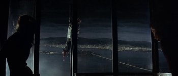 Movie still from “The Towering Inferno” (1974), directed by John Guillermin – A man hanging from a rope in the dark; Extreme Wide shot, Low angle