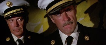 Movie still from “The Towering Inferno” (1974), directed by John Guillermin – A man wearing a uniform and a hat; Close Up shot, Low angle