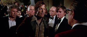 Movie still from “The Towering Inferno” (1974), directed by John Guillermin – A group of men standing next to each other in a room; Medium shot, Over the shoulder angle