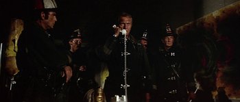 Movie still from “The Towering Inferno” (1974), directed by John Guillermin – A group of men standing next to each other; Medium shot, Low angle