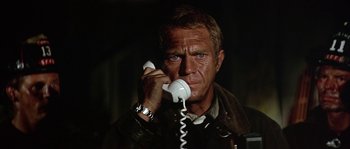 Movie still from “The Towering Inferno” (1974), directed by John Guillermin – A man talking on a phone while wearing a leather jacket; Close Up shot, Low angle