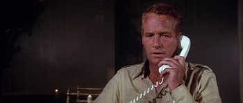 Movie still from “The Towering Inferno” (1974), directed by John Guillermin – A person talking on a phone; Close Up shot, Low angle
