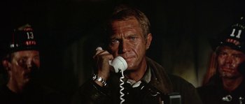 Movie still from “The Towering Inferno” (1974), directed by John Guillermin – A person talking on a phone; Close Up shot, Low angle