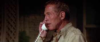 Movie still from “The Towering Inferno” (1974), directed by John Guillermin – A person talking on a phone; Close Up shot, Low angle