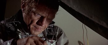 Movie still from “The Towering Inferno” (1974), directed by John Guillermin – A person holding a cell phone; Close Up shot, Low angle