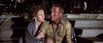 Movie still from “The Towering Inferno” (1974), directed by John Guillermin – A man and a woman sitting next to each other on the ground; Close Up shot, Low angle