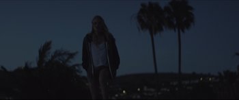 Movie still from “The Tribes of Palos Verdes” (2017), directed by Brendan Malloy – A woman standing on a hill at night with trees in the background; Medium shot, Low angle