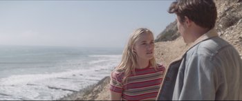 Movie still from “The Tribes of Palos Verdes” (2017), directed by Brendan Malloy – A woman standing next to a man on the beach; Medium shot, Over the shoulder angle