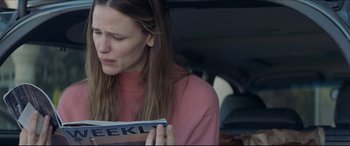 Movie still from “The Tribes of Palos Verdes” (2017), directed by Brendan Malloy – A woman sitting in the back of a car looking at a magazine; Close Up shot, Over the shoulder angle