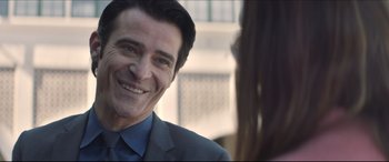 Movie still from “The Tribes of Palos Verdes” (2017), directed by Brendan Malloy – A person wearing a suit and smiling; Close Up shot, Over the shoulder angle