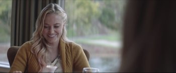 Movie still from “The Tribes of Palos Verdes” (2017), directed by Brendan Malloy – A woman sitting at a table with a glass of water; Close Up shot, Over the shoulder angle