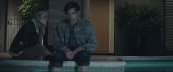 Movie still from “The Tribes of Palos Verdes” (2017), directed by Brendan Malloy – A man sitting on the ground in front of a building; Medium shot, Low angle