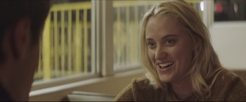 Movie still from “The Tribes of Palos Verdes” (2017), directed by Brendan Malloy – A person sitting in a chair smiling; Close Up shot, Over the shoulder angle