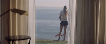 Movie still from “The Tribes of Palos Verdes” (2017), directed by Brendan Malloy – A woman standing on the grass looking out at the ocean; Wide shot, Low angle