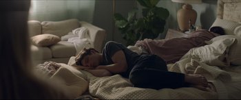 Movie still from “The Tribes of Palos Verdes” (2017), directed by Brendan Malloy – A young man sleeping on a bed in a living room; Medium shot, High angle