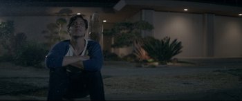 Movie still from “The Tribes of Palos Verdes” (2017), directed by Brendan Malloy – A man sitting on the ground looking up at the sky; Medium shot, Over the shoulder angle