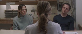 Movie still from “The Tribes of Palos Verdes” (2017), directed by Brendan Malloy – Three people are sitting in a room and one person has a ponytail; Medium shot, Over the shoulder angle