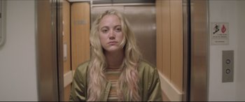 Movie still from “The Tribes of Palos Verdes” (2017), directed by Brendan Malloy – A woman with long blonde hair is standing in front of an elevator; Close Up shot, Low angle