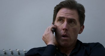 Movie still from “The Trip to Spain” (2017), directed by Michael Winterbottom – A person talking on a cell phone; Close Up shot, Low angle