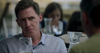 Movie still from “The Trip to Spain” (2017), directed by Michael Winterbottom – A person sitting at a table in a restaurant; Close Up shot, Over the shoulder angle