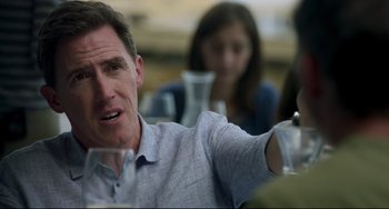 Movie still from “The Trip to Spain” (2017), directed by Michael Winterbottom – A person sitting at a table; Close Up shot, Over the shoulder angle