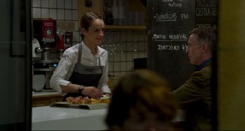 Movie still from “The Trip to Spain” (2017), directed by Michael Winterbottom – A woman sitting at a table in front of a person; Medium shot, Over the shoulder angle