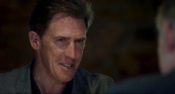 Movie still from “The Trip to Spain” (2017), directed by Michael Winterbottom – A man's face in a dark room; Close Up shot, Over the shoulder angle