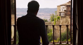 Movie still from “The Trip to Spain” (2017), directed by Michael Winterbottom – A man standing on a balcony looking out over a valley; Wide shot, Low angle