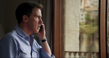 Movie still from “The Trip to Spain” (2017), directed by Michael Winterbottom – A person talking on a cell phone; Medium shot, Over the shoulder angle