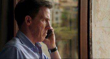 Movie still from “The Trip to Spain” (2017), directed by Michael Winterbottom – A person talking on a cell phone; Close Up shot, High angle