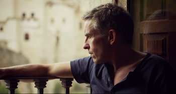 Movie still from “The Trip to Spain” (2017), directed by Michael Winterbottom – A person leaning on a railing; Close Up shot, Low angle