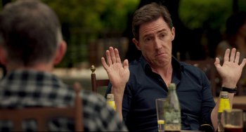 Movie still from “The Trip to Spain” (2017), directed by Michael Winterbottom – A man sitting in front of another man at a table; Medium shot, Over the shoulder angle