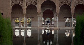 Movie still from “The Trip to Spain” (2017), directed by Michael Winterbottom – A man standing in a pool of water near a building; Extreme Wide shot, Low angle